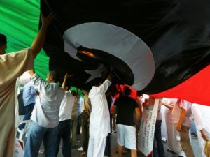 Tripoli residents display a flag at a rally in support of the Libya Dawn militia.  (AFP/File)