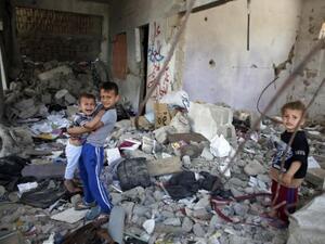 Palestinian children sit in the rubble of their home, destroyed during last summer's conflict between Israel and Hamas militants in the Gaza Strip.  (AFP/Thomas Coex)