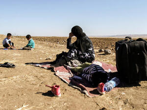 A Syrian refugee woman watches children playing close to the town of Semalka (Image credit: AFP)