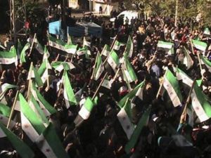 متظاهرون ضد الرئيس السوري بشار الاسد يلوحون بالاعلام السورية القديمة خلال مسيرة بالقرب من درعا يوم الاحد. 