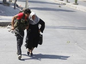 مقاتل من المعارضة يساعد عجوز على عبور شارع في حلب/ارشيف