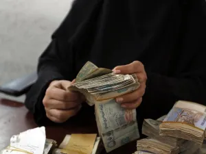 A Yemeni woman holds onto YER (AFP/FILE)