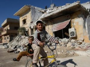 اطفال سوريون يلعبون وسط الدمار في اتارب بالقرب من حلب/أ.ف.ب