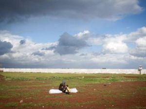 سورية شردتها الحرب مع طفلها تنتظر بناء خيمة لها في مخيم باب السلام على الحدود مع تركيا/أ.ف.ب