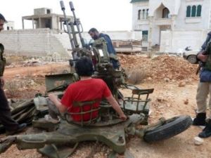 مقاتلون من المعارضة على مدفع رشاش في مركز قيادة الفوج في الشيخ سليمان/أ.ف.ب