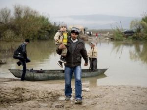 مواطن سوري يحمل طفله في جسر الشغور لاجئا الى تركيا/أ.ف.ب