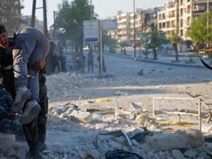 مقاتل من المعارضة يحمل زميله الذي سقط في معركة سيف الدولة بحلب/أ.ف.ب