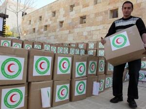 رجل ينقل مساعدات قدمها الهلال الاحمر الايراني للاجئين السوريين في الاردن/أ.ف.ب