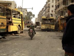 مقاتل من المعارضة يجتاز منطقة يسيطر عليها قناصة النظام على دراجة نارية في حي بستان الباشا بحلب/أ.ف.ب