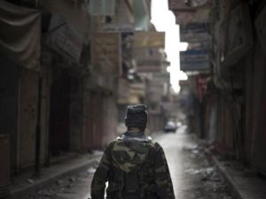 مقاتل من المعارضة يسير في شارع ست الربى في دير الزور/أ.ف.ب