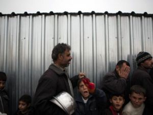 لاجئون سوريون يقفون في طابور لاستلام معونات غذائية في مخيم بالقرب من مدينة اعزاز شمالا/أ.ف.ب