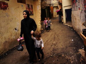 A Syrian woman displaced by the war walks with her child in a neighborhood with a high concentration of Syrian refugees on November 9, 2013 in Beirut, Lebanon.  [Spencer Platt/Getty Images]