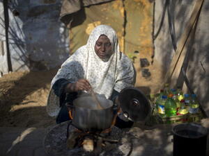 A Palestinian woman cooks her food on fire wood in Biet Hanun northern Gaza Strip, on November 19, 2013, due to the shortage in butane gas across the Hamas run Palestinian territory. [AFP]