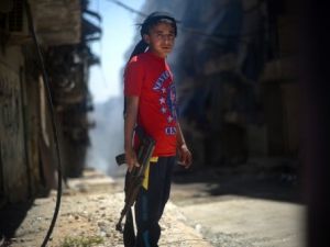 طفل سوري يحمل بندقية كلاشينكوف في حي الشيخ مقصود بحلب /أ.ف.ب