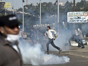 Egyptian students of al-Azhar university run for cover from a tear gas canister fired by riot police during clashes outside their university. [ AFP photo / Khaled Desouki]