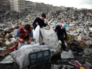 اطفال وشباب سوريون يبحثون في القمامة في مدينة حلب عن اغراض بلاستيكية ومواد اخرى صالحة لاعادة التدوير/أ.ف.ب