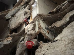 سوري ينقل بسلة بلاستيكية اغراضا من بيته المدمر بفعل القصف الجوي في حلب/أ.ف.ب