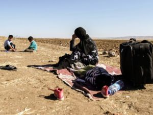 لاجئة سورية مع اطفالها في انتظار نقلها لتركيا/أ.ف.ب