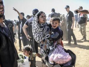 A Syrian Kurdish woman crosses the border between Syria and Turkey at the southeastern town of Suruc in Sanliurfa province on September 23, 2014.  (AFP/Bulent Kilic)