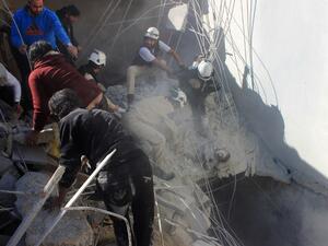 Members of the civil defence pull a boy out from under the rubble of a building following air strikes by suspected Russian warplanes backing the Syrian government on the Sahour neighbourhood of the northern Syrian city of Aleppo on February 16, 2016. (AFP/Thaer Mohammed)