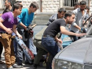 مواطنون سوريون يحاولون اسعاف جريح في التفجير الذي وقع ، الثلاثاء، في المرجة وسط دمشق/أ.ف.ب