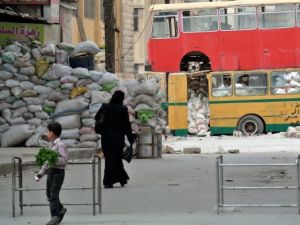 استخدام الحافلات لتجنب رصاص القناصين في شوارع مدينة حلب/أ.ف.ب