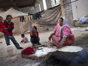 عائلة سورية مهجرة من منزلها في منطقة الشيخ نجار الصناعية في حلب / أ.ف.ب