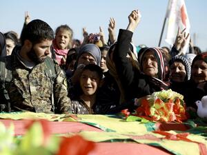 Syrian Kurds mourn next to coffins as they attend the funeral procession of four Kurdish fighters in the northeastern Syrian city of Qamishli on February 18, 2016. (AFP/Delil Souleiman)