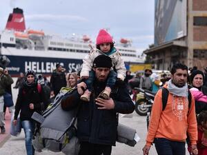 Hundreds of migrants and refugees walk at the port of Piraeus upon their arrival from the island of Lesbos on February 10, 2016. (AFP/Louisa Gouliamaki)