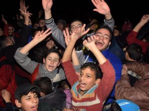 Syrians celebrate on December 12, 2016 in the government-held Mogambo neighbourhood of the northern Syrian city of Aleppo, after rebel fighters retreated into a small pocket of their former bastion in the face of new army advances. (AFP/George Ourfalian)