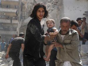 A Syrian civil defence member and a volunteer carry a little girl rescued from under the rubble of destroyed buildings following a reported airstrike on the rebel-held Salihin neighbourhood of the northern city of Aleppo, on September 10, 2016. (AFP/Thaer Mohammed)