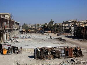 The carcass of a bus litters a bombed-out street in Ramussa on September 9, 2016, after pro-regime fighters took control of the strategically important district on the outskirts of the Syrian city of Aleppo yesterday. (AFP/George Ourfalian)