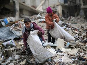 Syrian youths collect wood from rubble to be used for heating and cooking, on December 27, 2016, in the Damascus rebel-held eastern suburb of Zamalka. (Amer al-Mohibany)