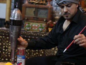 Syrian artist Ekrem Abu al-Fevz is seen with one of his art pieces. (Twitter)