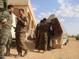 US-backed Kurdish and Arab fighters chat as they advance into the Islamic State (IS) jihadist's group bastion of Manbij, in northern Syria, on June 23, 2016. (AFP/Delil Souleiman)