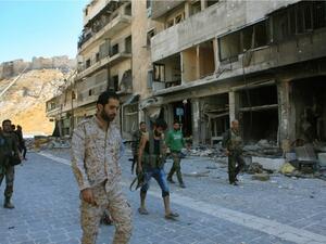 Syrian pro-government forces are seen on September 28, 2016 in the Farafira district, northwest of Aleppo's historic citadel. Syria's army took control of the rebel-held district after days of heavy air strikes that sparked allegations of war crimes. (AFP/Georges Ourfalian)