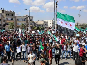 Syrians from Idlib and its surrounding towns wave the flag of the opposition and chant slogans as they gather for an anti-government demonstration in a main square on September 14, 2018. (OMAR HAJ KADOUR / AFP)
