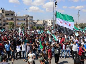 Syrians from Idlib and its surrounding towns wave the flag of the opposition and chant slogans as they gather for an anti-government demonstration in a main square on September 14, 2018. (OMAR HAJ KADOUR / AFP)
