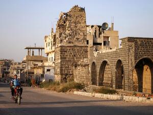 A Syrian man rides a motorcycle while carrying a gas cylinder as he drives past the Omari mosque in a rebel-held area in the southern Syrian city of Daraa on October 2, 2018. (Mohamad ABAZEED / AFP)