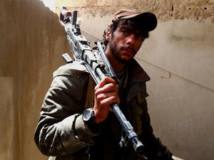 A fighter from the Syrian Democratic Forces poses with a machine gun in Tabqa, April 30 2017. (AFP/Delil Souleiman)