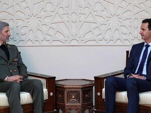 Iranian defence minister Amir Hatami, left, meets with Syrian president Bashar Al Assad in Damascus. (SANA/AFP)