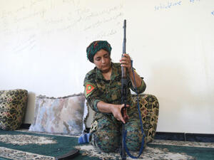 Yazidi fighter Heza prepares her rifle in an abandoned home used as a base on the eastern outskirts of Raqa on July 18, 2017. (AFP)