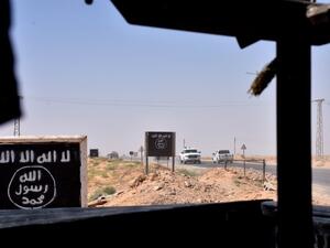 Billboards show the logo of the Islamic State (IS) group in the northern countryside of Deir Ezzor, where Syrian pro-government forces are holding a position on September 9, 2017 (George Ourfalian/AFP)
