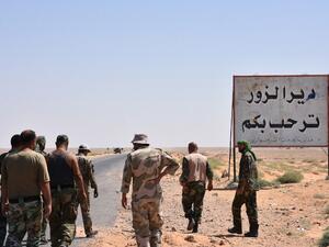 Members of the Syrian government forces stand on the entrance to Deir Ezzor city on September 3, 2017 (AFP)