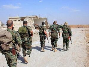 Syrian regime soldiers walk down a road in an area around Kweyris military airport, in the eastern Aleppo. (AFP/ File)