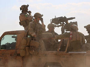 Armed men in uniform identified by Syrian Democratic Forces as US special operations personnel ride in a pickup truck in the village of Fatisah in the northern Syrian province of Raqa on May 25, 2016 (AFP/Delil Souleiman)