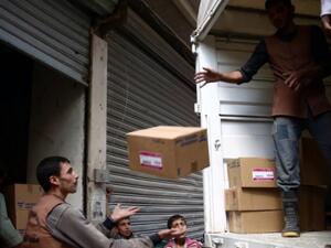 Members of the Syrian Arab Red Crescent delivering aid to a regime-besieged town. (AFP/File)