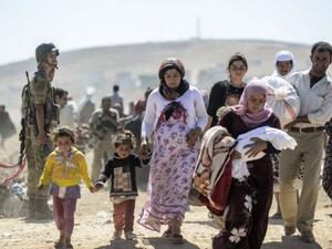 Syrian refugees carrying their belongings. (AFP/File)