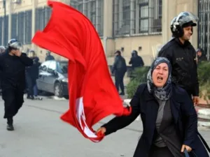 تونسية تلوح بعلم البلد وسط العاصمة احتفالا بمغادرة الرئيس/أ.ف.ب