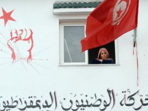 تونسية تطل من نافذة بيتها على مراسم تشييع بلعيد في جبل جلود مسقط رأس بلعيد/أ.ف.ب